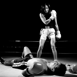 Female boxer knocking out male boxer